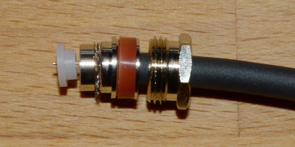 Abbildung 13: Das Abschirmgeﬂecht wird mit dem Metallring ﬁxiert und der Isolator für den Mittelstift wird eingesetzt.